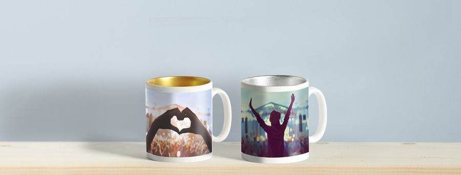 one silver mug, one gold mug with concert photos